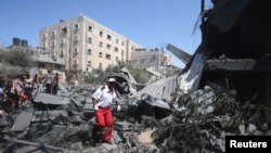 巴勒斯坦醫護人員在加沙地帶南部的一棟被以色列飛機炸毀的房屋廢墟上尋找救援目標