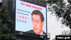 在台灣標誌性建築“台北101”大樓前十字路口的大型霓虹燈電子廣告看板上播出慶祝王炳章生日的圖片。 （2024年12月28日，影片截圖）