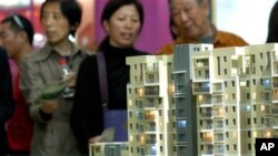 南京的市民在房地產交易會上觀看公寓樓的模型(資料圖片)