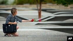 资料照：一名女子于9-11这一天在五角大楼纪念园献花。摄于2014年。