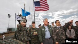 Министры обороны Южной Кореи Ким Гван Чжин (на переднем плане справа) и США Чак Хейгел (второй справа) во время посещения Корейской демилитаризованной зоны. Южная Корея. 30 сентября 2013 г.