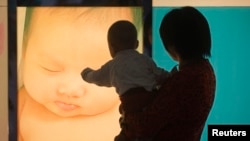 在广州妇产医院，一位女性抱着孩子的背影