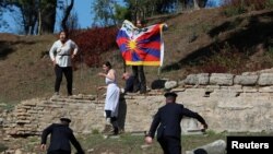 手举自由西藏旗帜的抗议者在奥林匹克圣火火炬点燃仪式上抗议，希腊警察前去拦截拘捕。（2021年10月18日）