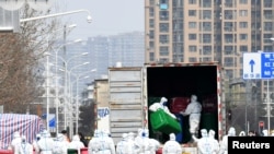 身穿防护服的工人在清理清理武汉华南海鲜市场。这里曾被认为是新冠病毒的发源地。（2020年3月4日）