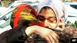 2015年2月12日美国北卡罗来纳州罗利市的民众在一座清真寺为三名遇害的穆斯林学生举行葬礼。图为两位穆斯林妇女在清真寺外面相拥哭泣