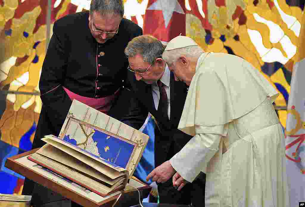 Pope Benedict presents a replica of Tolomeus Geography book to Cuba's President Raul Castro, center, during a meeting in Havana. (AP)