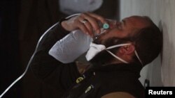 一名民间组织工作人员戴上面罩呼吸。