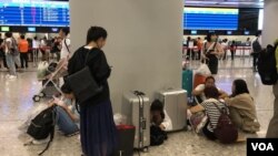 有旅客在西九高鐵站大堂席地而坐。(美國之音湯惠芸拍攝)