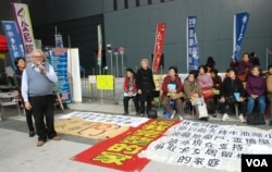 甘浩望神父(左一)帶領超過30名港人大陸超齡子女的家長，在政府總部外靜坐