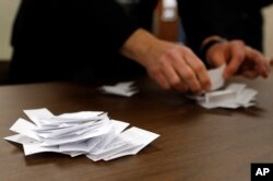 FILE - Precinct chair John Anderson counts votes for Republican candidates during a caucus in Nevada, Iowa, Monday, Feb. 1, 2016.