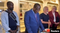 尼日尔内政部长苏莱（中）宣布美国人质伍德克和法国人质杜波依斯（右左）获释。（2023年3月20日）