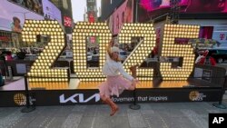 ນັກເຕັ້ນໂພສທ່າໃນການຖ່າຍຮູບ ຢູ່ດ້ານໜ້າປ້າຍປີ 2025 ທີ່ Time Square ໃນນະຄອນນິວຢອກ, ວັນທີ 18 ທັນວາ 2024. (AP Photo/Ted Shaffrey)