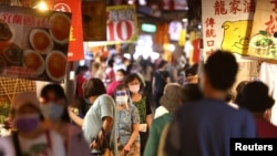 台灣台北市民眾戴著口罩逛夜市。（2021年7月6日）