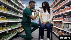 資料照片：一位女士在賓夕法尼亞州施文卡斯維爾的斯基帕克藥店接種輝瑞疫苗加強針。 (2021年8月14日)