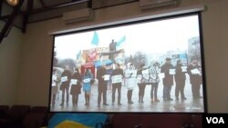 2014年在莫斯科的一場研討會上，烏克蘭活動人士展示國旗和烏克蘭反政府示威活動視頻。（美國之音白樺攝）