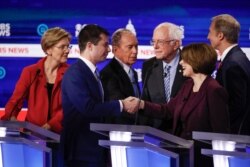 From left, Democratic presidential candidates, Sen. Elizabeth Warren, D-Mass., former South Bend Mayor Pete Buttigieg, former New York City Mayor Mike Bloomberg, Sen. Bernie Sanders, I-Vt., Sen. Amy Klobuchar, D-Minn., and businessman Tom Steyer, greet one another at the end of the Democratic presidential primary debate, Feb. 25, 2020, in Charleston, S.C..