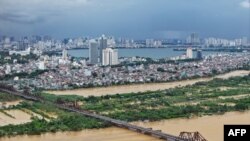 ຮູບພາບທີ່ຖ່າຍທາງອາກາດໃບນີ້ ສະແດງໃຫ້ເຫັນ ແມ່ນໍ້າແດງທີ່ຖ້ວມລົ້ນ ໃນ ນະຄອນຫຼວງ ຮາໂນ່ຍ ໃນວັນທີ 10 ກັນຍາ 2024, ພາຍຫຼັງພາຍຸ ໄຕ້ຝຸ່ນ ຢາກີິ ພັດຂຶ້ນຖະຫຼົ່ມ ພາກເໜືອຂອງຫວຽດນາມ.