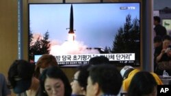 人们在韩国首尔一个地铁站的屏幕前看朝鲜导弹试射的新闻，2019年7月25日