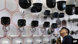  2019年10月29日深圳举行的中国公安博览会上一名男子在仔细观看华为生产的监视摄像头 