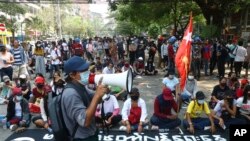 周六（3月27日）缅甸仰光淡汶鎮抗议民众占领一条街道同军警对峙。（美联社照片）