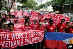 越南人和菲律宾人在中国驻菲律宾领事馆前示威，标语牌上写着“对中国人说不”，“世界支持越南和菲律宾”
