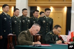 美军参联会主席邓福德上将（前左）与中国中央军委联合参谋部参谋长房峰辉在北京签署协议。 （2017年8月15日）