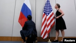 Сотрудник устанавливает российский флаг рядом с флагом США (архивное фото)