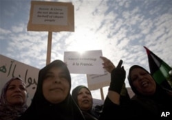 利比亚妇女在班加西集会高举英语标语牌,上写"俄国中国不代表利比亚人民"和"多谢法国"（3月23日）