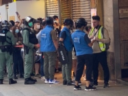 香港警方6月28日下午在旺角登打士街展开大围捕，传媒联络队人员检查采访期间被封锁线围困记者的证件才放行。 (美国之音/汤惠芸)