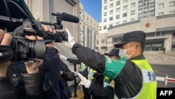 一名警察擋住記者的鏡頭阻止拍攝審訊公民記者張展的上海浦東新區法院外景。 （2021年12月28日）