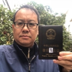 中国维权律师刘晓原手举律师“失业证” （推特照片）