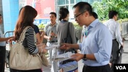 香港立法會選舉會計界參選人梁繼昌(右)在街上向市民派發傳單