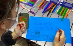 有香港市民11月30日晚在旺角街站寫聖誕卡給12港人。(美國之音特約記者湯惠芸攝)