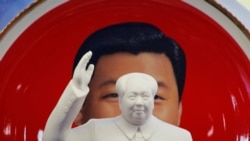 北京天安门附近一个纪念品商店里毛泽东的塑像摆在习近平纪念画盘的前面。（2018年3月1日）