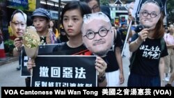 遊行人士手持在監獄服刑的邵家臻及戴耀廷的頭像，代替他們出來遊行 (攝影：美國之音湯惠芸）