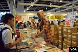 18歲的中六畢業生王同學(左)購買有關中文字及廣東話文化的書籍，與彭志銘討論廣東話文化。(美國之音湯惠芸)