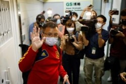 現任香港記者協會主席丶《立場新聞》副採訪主任陳朗昇離開《立場新聞》辦公室時向媒體招手。 （2021年12月19日）