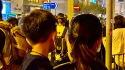 香港市民顏小姐抱著6歲的兒子8月31日晚在太子地鐵站出口獻花，悼念8-31事件死難者。(美國之音湯惠芸攝）