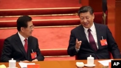 资料照片：中共总书记习近平和前总书记胡锦涛在十九大开幕式上交谈。（2017年10月18日）