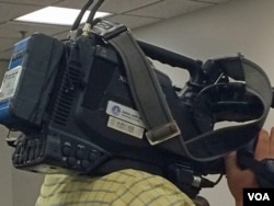 在六四纪念活动现场“采访”的新华社记者。（美国之音安华拍摄）