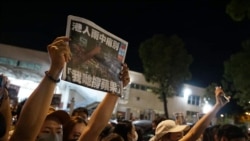 支持者在6月24日凌晨聚集在香港蘋果日報總部外，舉起最後一的《蘋果日報》並高呼支持蘋果的口號（照片來源：美國之音粵語組聽眾鄭先生）