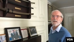 前美国在台协会台北办事处处长杨苏棣在杨家祖宅受访时展示挂在墙上的传家之宝军刀与前美国总统奥巴马的合照。