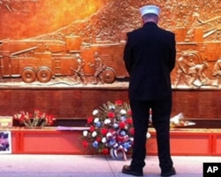 一名消防仪仗队员在世贸中心旧址附近的遇难消防队员纪念墙前静思