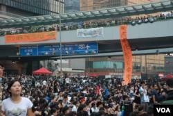 參與佔領中環行動人士在金鐘一座天橋掛上打氣和抗議的布條。（美國之音湯惠芸攝）