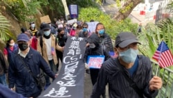 遊行人士拉著大型標語要求特首林鄭月娥交待懲教署製造的CSI口罩去向 （攝影：美國之音湯惠芸）