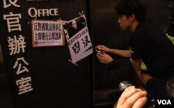 示威者將反對中國《國歌法》立法聯署聲明及抗議標語貼在特首辦公室入口外。(美國之音湯惠芸)