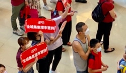 在观塘一个商场观看奥运电视直播的市民手持标语，支持香港单车选手李慧诗。 （美国之音/汤惠芸）