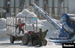 2005年 10月，新疆石河子生产建设兵团的一个棉花加工厂的工人们在工作。（资料照片）