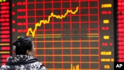 2016年1月29日，中國安徽省一名投資人正在查看證券公司的電子顯示器上的股票資訊。