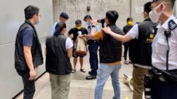 數十名警員包圍準備遊行的4名社民連成員及採訪的記者，逐一搜查遊行人士的背包、登記身分證資料，並有警員全程錄影，面對一些4人遊行，佈防非常嚴密。（美國之音湯惠芸)